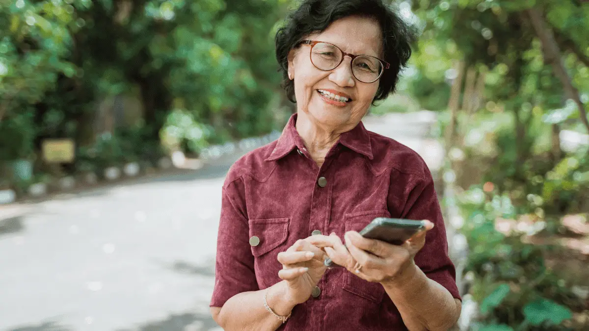 Smiling Asian Old Woman Using a Cell Phone