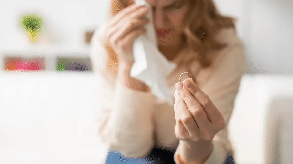 A divorced woman holding her wedding ring