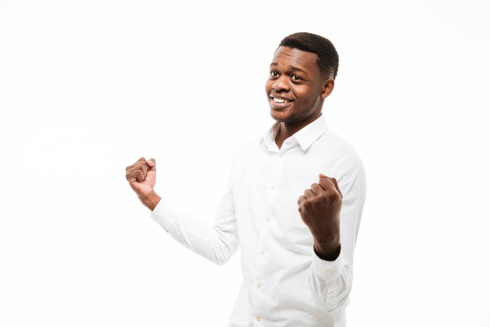 A man making winner gestures to show how to become a more positive person