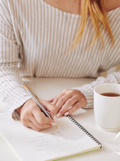 A woman writing down affirmations for winning