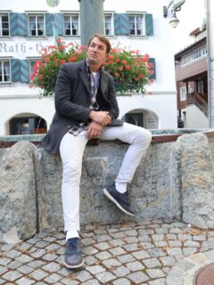 a man sitting on a stone bench in front of a building