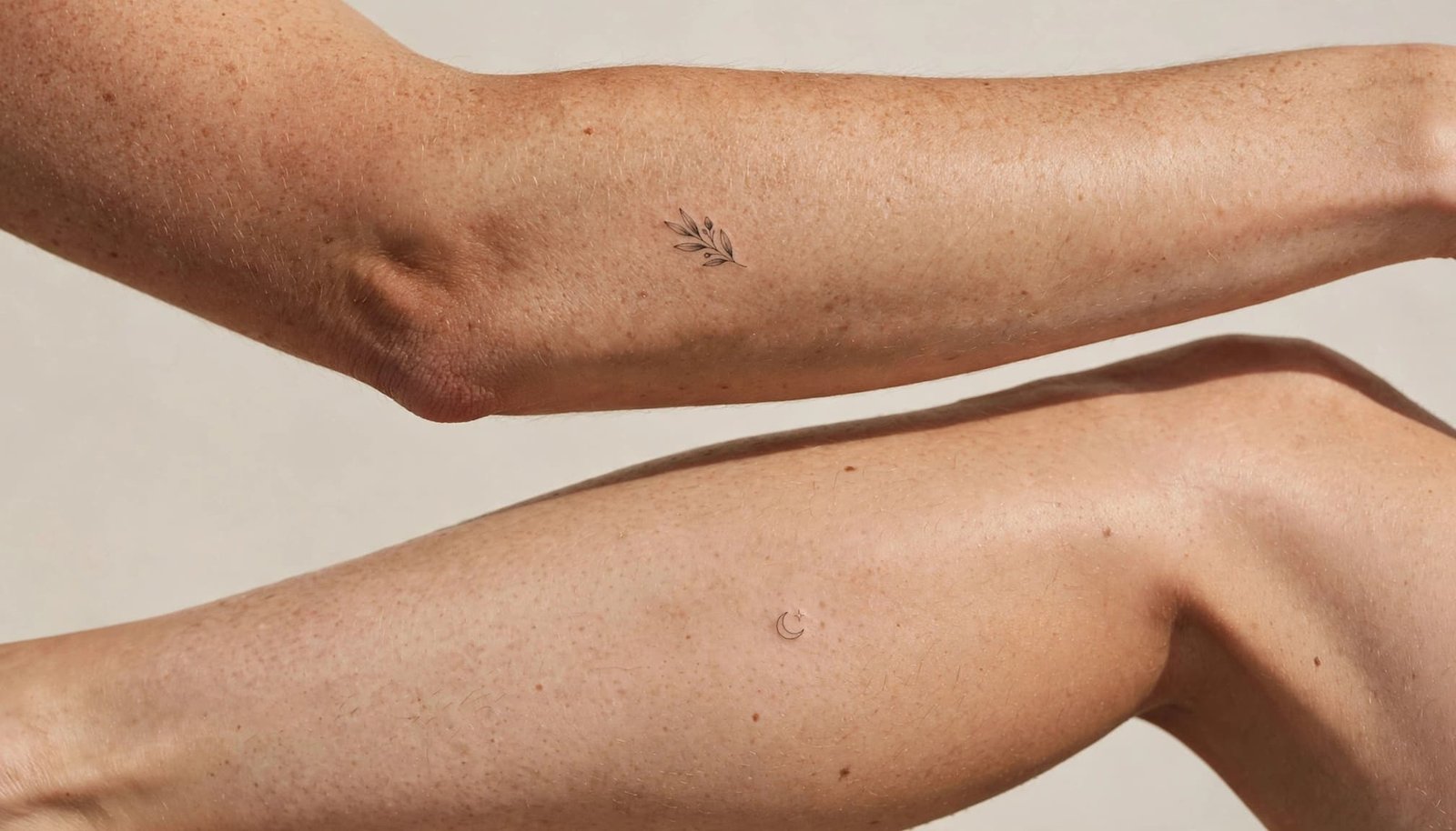 Tiny tattoos appear on the outer forearm and outer calf in soft natural light.